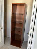 Front view of tall cherry MDF cabinet showing four glass shelves and interior light