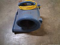 Left-front view showing overall unit, fan grille, blue housing, yellow cord