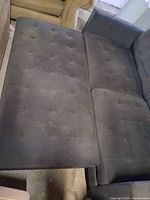 Chaise cushion and seat area showing button tufting and wear