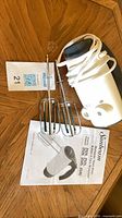 Mixer body with coiled cord, beaters, manual visible