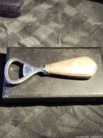 Full view of bottle opener showing sterling handle and stainless head