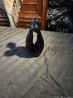 Full view of black Murano glass figurine standing upright