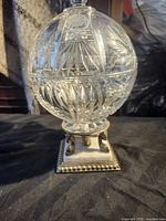 Full view of cut crystal covered jar on marble base