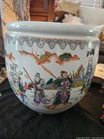 Side view showing figural scene and rim border of fishbowl