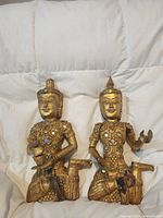Front view of both gilded wood statues showing overall form and condition