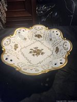Top view of scalloped porcelain bowl showing gold floral design and pierced rim