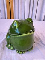 Front view of green ceramic frog bowl with lid