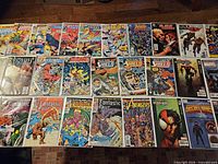 Overview of roughly 30 bagged Marvel comics laid out on table