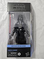 Front view of boxed Darth Vader figure showing accessory and branding