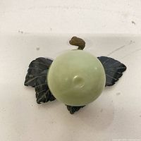 Top view showing apple shape, two carved leaves, stem