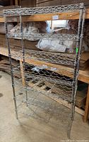 Front view of full-height chrome wine rack showing five wave shelves and frame
