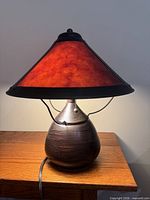 Lamp lit showing copper shade glow, base, pull chains