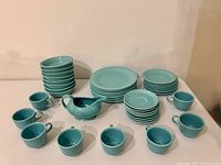 Full dinnerware set arranged: stacks of plates, bowls, saucers, cups, gravy boat