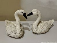 front view of both white swan sculptures