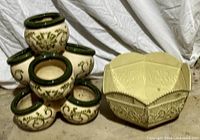 Front view of both planters showing shapes, colors, and decorative motifs
