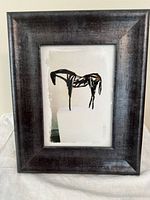 Front view of smaller frame with abstract horse print in dark wood frame