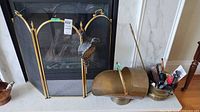 Fireplace screen, brass coal scuttle tipped on side, bellows hanging on screen