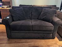 Front view of dark brown corduroy loveseat with cushions and pillows