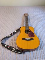 Front view of Yamaha FG-Junior guitar with attached strap