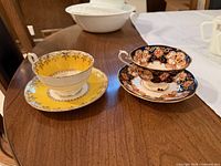 Two bone china teacup and saucer sets side by side on table