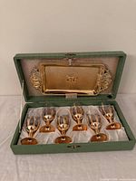 Open case showing six cordial glasses and tray in lid
