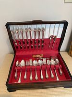 Flatware set in open wooden chest showing all utensils and layout