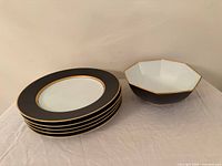 Stack of five oval plates beside octagonal bowl showing pattern and condition