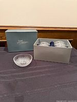 Open box showing six crystal bowls and exterior branded lid