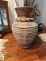 Full view of ceramic floor vase showing ribbed body and rope detail
