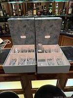 Both presentation boxes open showing ten glasses