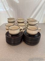 Front view of stacked saucers with cups behind, showing overall set