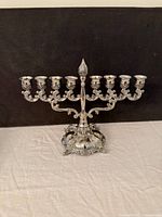 Front view of ornate silver-plated nine-branch menorah