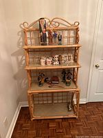 Front view of rattan baker's rack showing all four shelves and scroll details