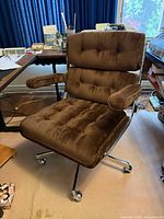 Full view of chair showing upholstery, armrests, chrome frame and base