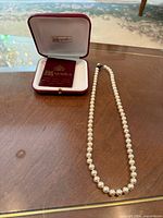 Necklace with presentation box open showing brand logo