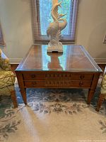 Front view of Bassett wood end table with glass top and drawer