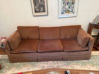 Front view of brown patterned three-seat sofa with cushions