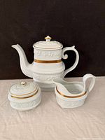 Front view of teapot, creamer, sugar bowl