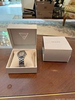 Watch in Guess presentation box beside outer lid on table