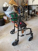 Left side view of black Nexus 3 rollator with seat, backrest and four wheels