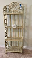 Full view of four-tier metal etagere with porcelain dish on second shelf