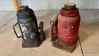 Black and red hydraulic bottle jacks side by side showing overall condition