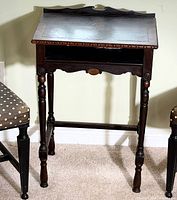 Front view showing overall form, gallery back, open shelf, turned legs