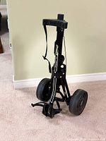 Full view of folded Bag Boy A-350 push cart showing wheels and frame