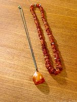 Full view of both jewellery pieces: amber chip necklace and butterscotch pendant on chain