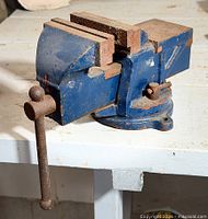 Overall view of blue bench vise on workbench