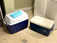 Two blue coolers side by side on floor, showing overall appearance