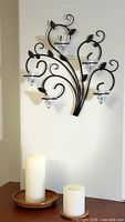 Wall candle holder with glass cups and two pillar candles on wood trays