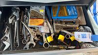 Entire drawer showing assorted wrenches, pliers, sockets, staple guns, drill bit set and flashlights