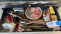 Open drawer view of assorted hand tools and hardware